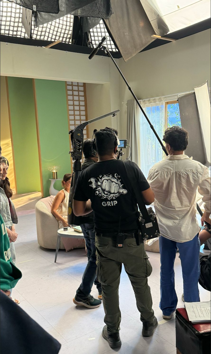 Lights On Films crew on set — boom operator and grip mid-take